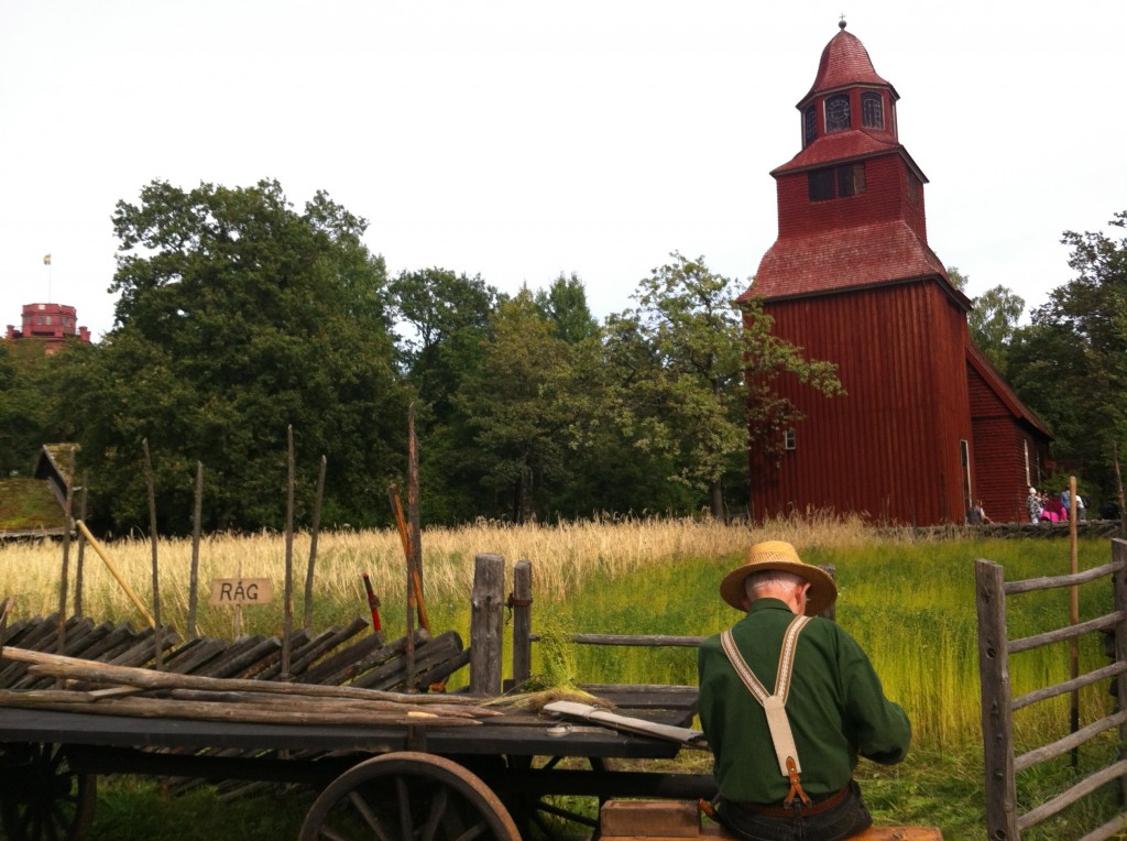 Farmer busy at his trade. The red building is Seglora Church from 1730 moved to Skansen in 1916. It’s still used for weddings today!