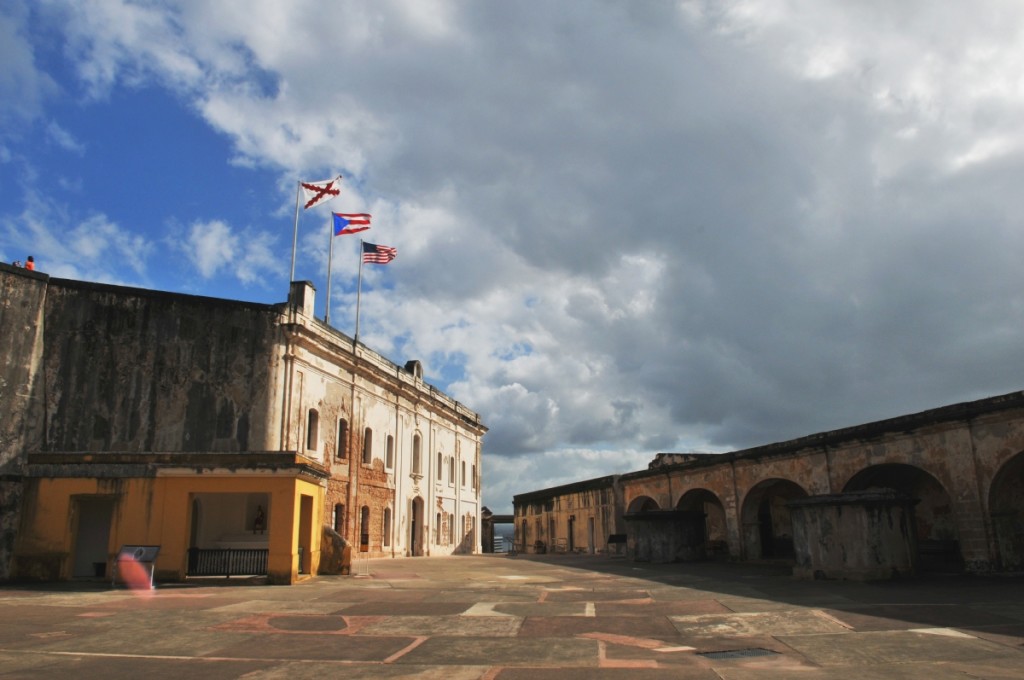 The three flags seen from the courtyard are the US flag, the Puerto Rican flag and the Cross of Burgundy, an old Spanish Military flag.